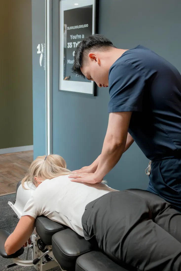Dr Ryan Tan adjusting a practice member's upper back