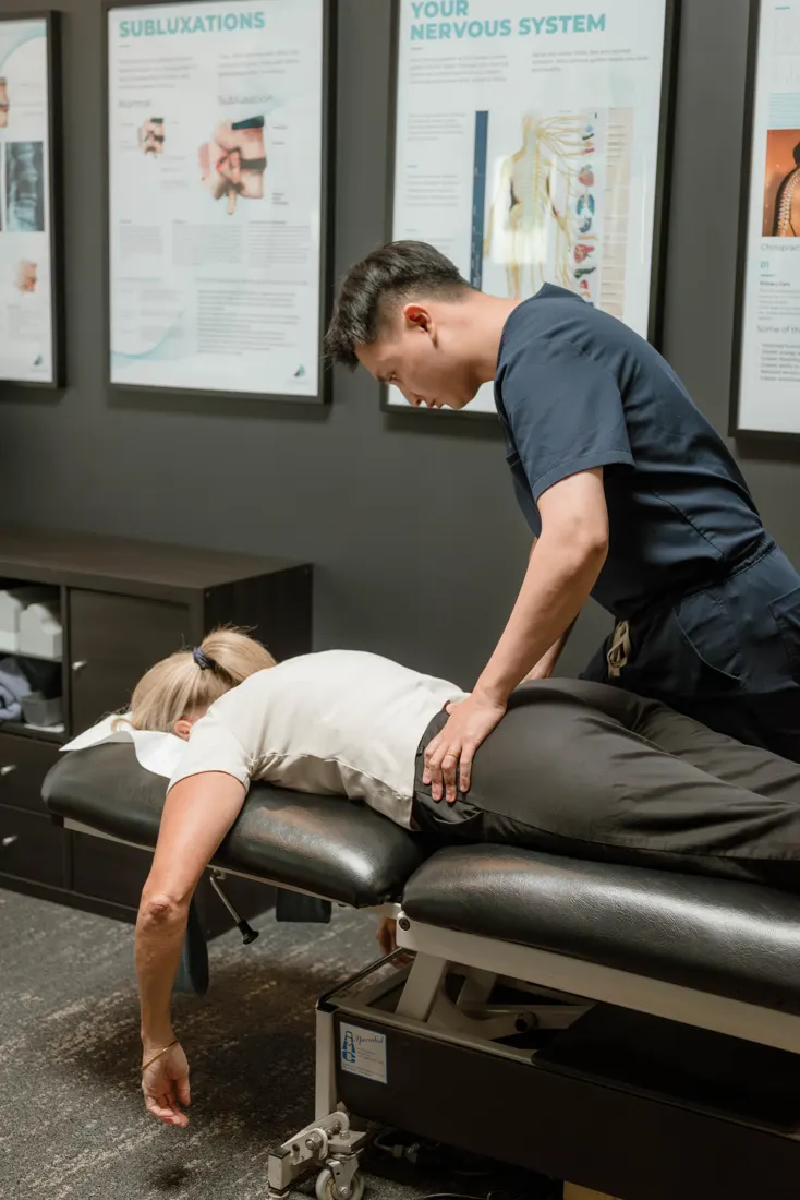 Dr Ryan Tan adjusting a practice member on the treatment table