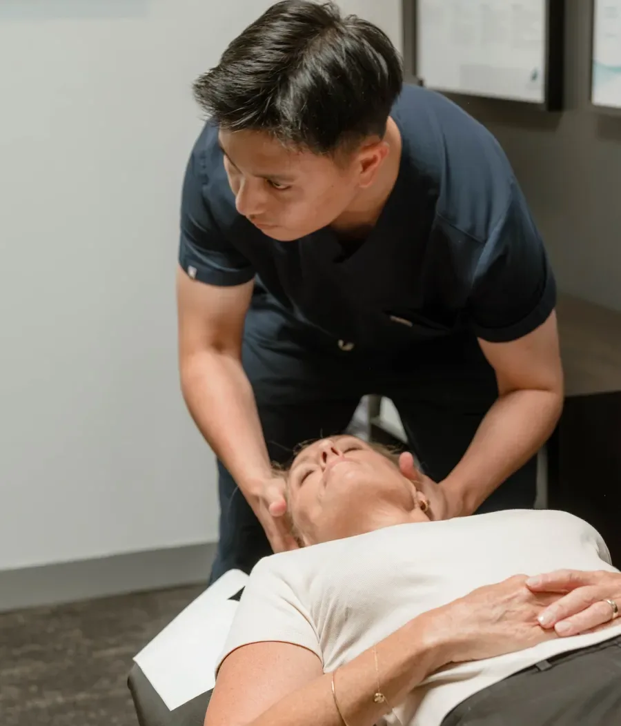 Dr Ryan Tan adjusting a practice member's neck